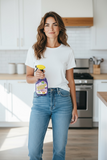 Woman holding a bottle of Simoniz Lavalosso cleaning spray in a kitchen