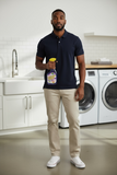 A man holding a bottle of Simoniz Green Scene Lavalosso cleaner in a laundry room.